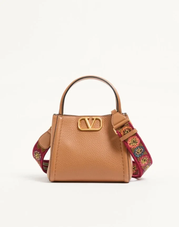 Valentino Garavani Alltime small handbag in grainy calfskin with embroidered ribbon shoulder strap